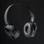 Close-up of wireless headphones on a dark background, showcasing design and texture.